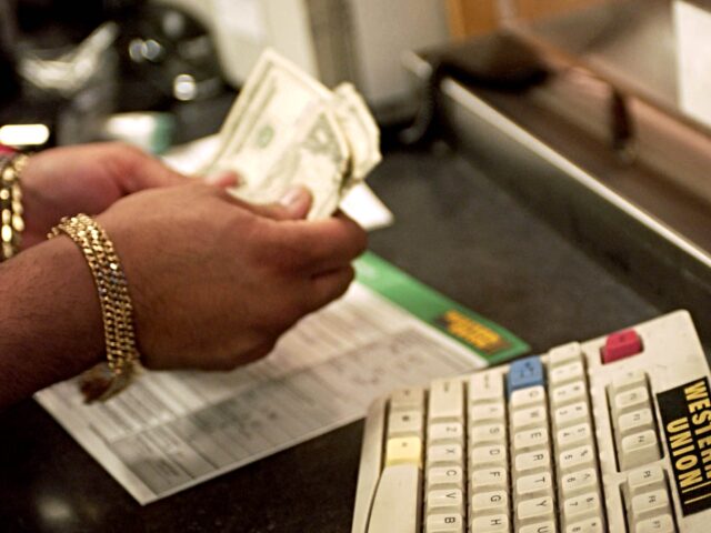 Sales Associate Johnny DeLaCruz counts money at a Western Union location in New York on Fe