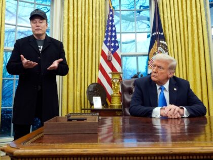 President Donald Trump listens as Elon Musk, joined by his son X Æ A-Xii, speaks in the O