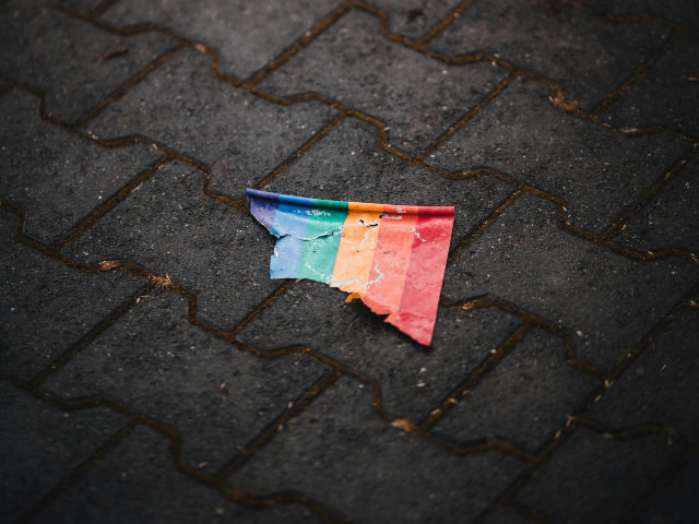Ripped Paper Rainbow Flag Lying on Sidewalk