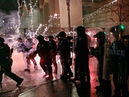 PORTLAND, OREGON, USA - DECEMBER 31: Protesters throw fireworks to police officers during