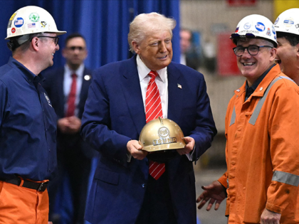 US President Donald Trump receives a gold helmet with his name on it during a visit to US