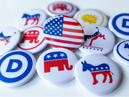 A pile of political buttons sitting on top of a table: Democratic Party and Republican Par
