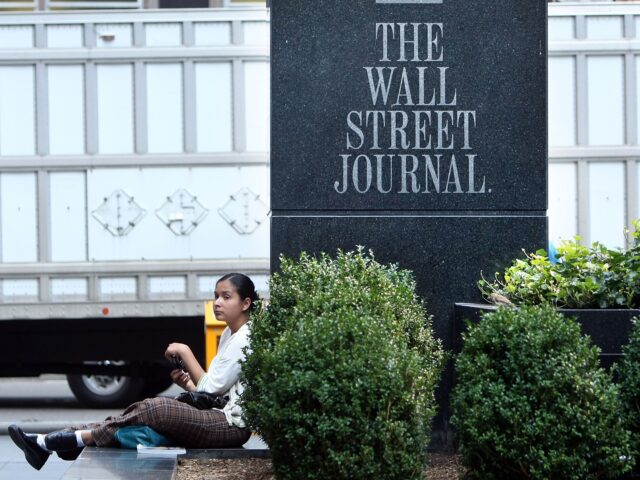 wall street journal NEW YORK - JULY 31: A woman sits in front of a sign outside a Wall Street Journal office o