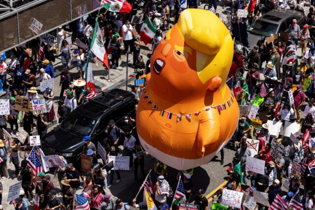 A 20-foot (6m)-tall balloon of US President Donald Trump in a diaper is seen among people