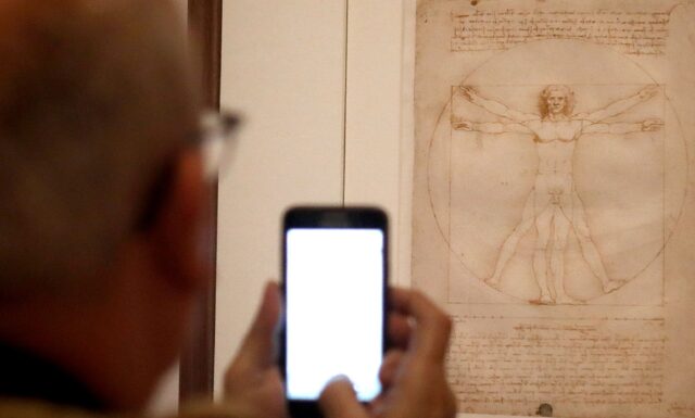 A man looks at Leonardo da Vinci's annotated drawing "Vitruvian Man", at an exhibition at