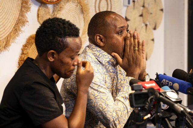 Boniface Mwangi, pictured seated to the left of fellow rights activist Agather Atuhaire, s