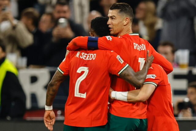 Cristiano Ronaldo (2nd R) is swamped by his teammates after scoring the winner for Portuga