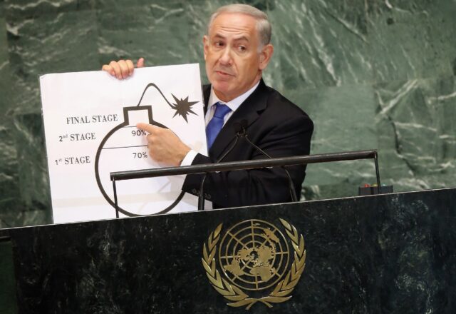 Israel's Prime Minister Benjamin Netanyahu shows a graphic of a bomb while discussing Iran
