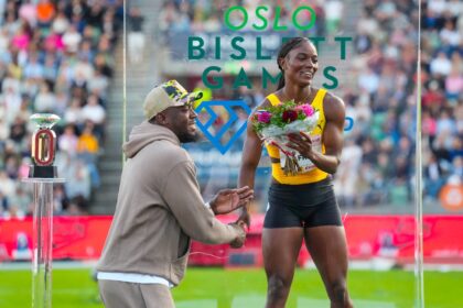 Jamaican sprint legend Usain Bolt presents flowers to Saint Lucia's Julien Alfred (R)
