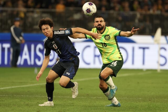 Japan’s Yu Hirakawa and Aziz Behich of Australia battle for the ball
