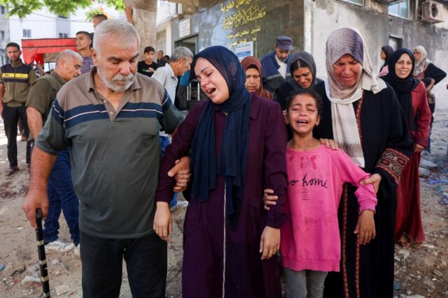 Mourners cry during a funeral of a person killed while attempting to get aid at a distribu