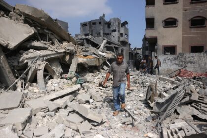 A Palestinian man walks beside the rubble of a house hit by overnight Israeli strikes in J