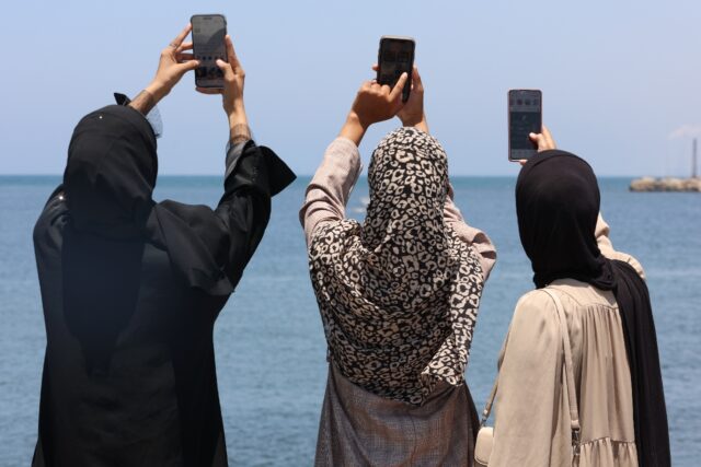 Palestinians raise their phones as they try to catch an internet signal in Gaza City