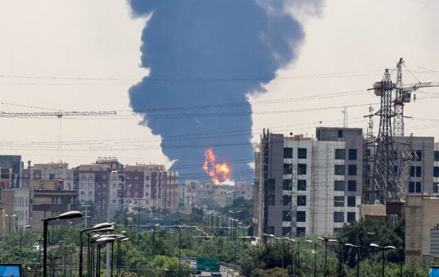 A plume of heavy smoke and fire rise over an oil refinery in southern Tehran, after an ove