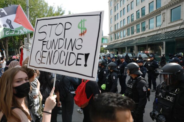 A protester holds a sign during a demonstration in front of Calgary City Hall on June 15,