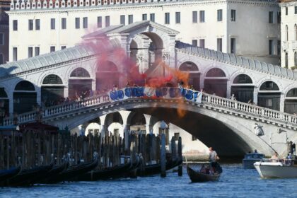 Protesters hang a 'No place for Bezos' banner on Venice's Rialto Bridge on