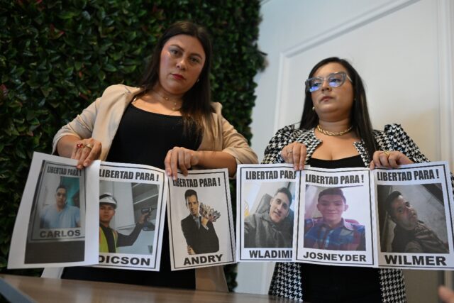 Reina Cardenas (L) and Jhoanna Sanguino hold pictures of Venezuelans deported from the Uni