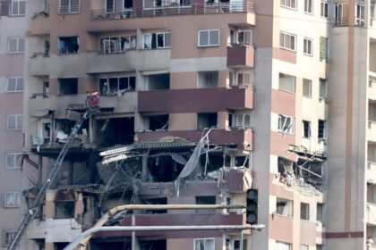 Rescue teams work outside a building targeted by an Israeli strike in the Iranian capital