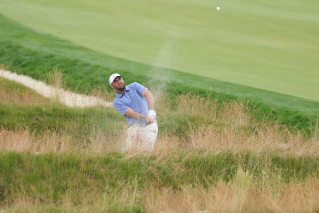 World number one Scottie Scheffler of the United States blasts out of the Church Pew bunke