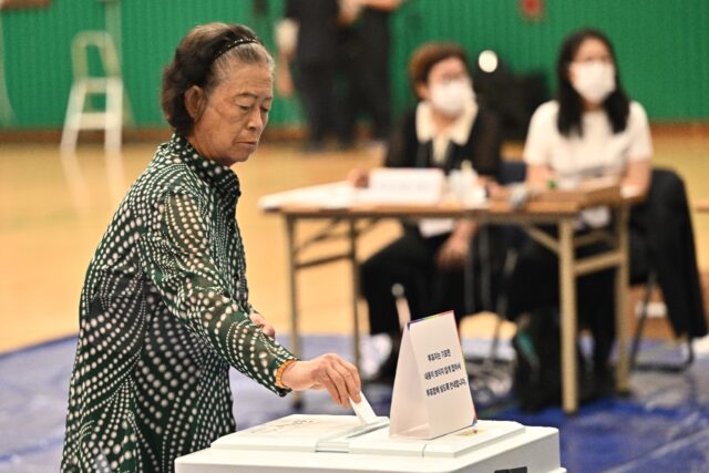 South Koreans, including this woman in Seoul, began casting their ballots in the country's