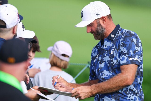Two-time major winner Dustin Johnson signs autographs for fans during a practice session a