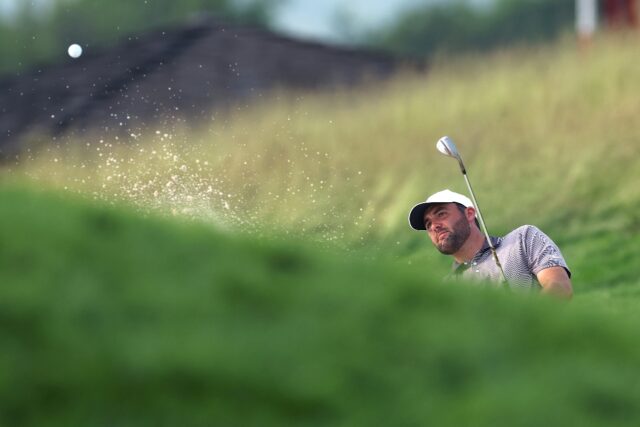 Top-ranked Scottie Scheffler of the United States plays a shot from the bunker on the 17th