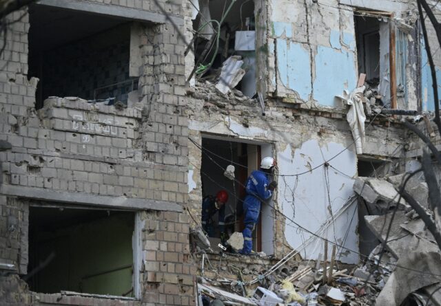 Ukrainian rescuers conduct a search operation in a residential building, heavily damaged f