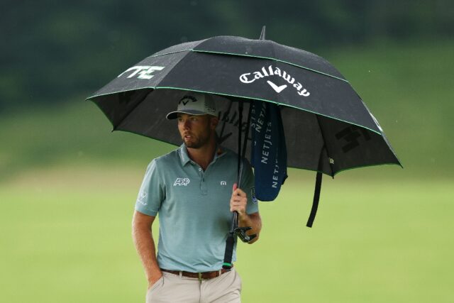 US Open leader Sam Burns of the United States waited under his umbrella as heavy rain halt