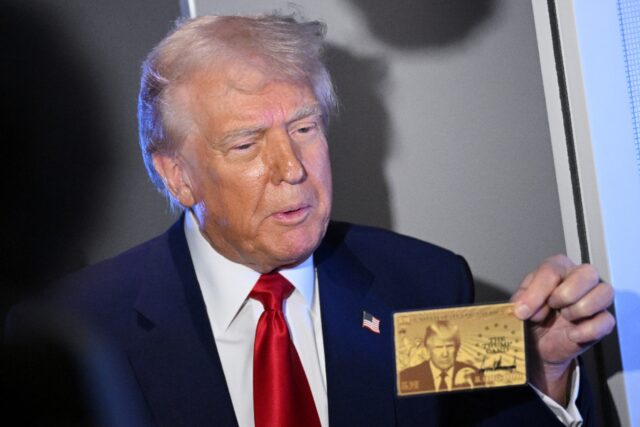US President Donald Trump holds the $5 million dollar Gold Card prototype while speaking t