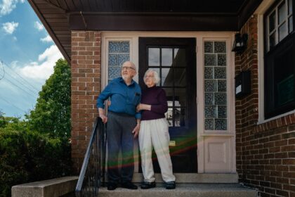 Veteran activists Joyce and Joseph Ellwanger stand on the steps of their home in Milwaukee