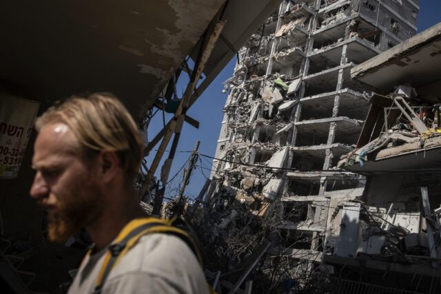A man walks past a heavily damaged building following an overnight Iranian missile strike