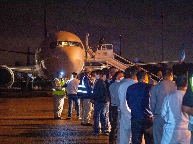 Guatemalan citizens wait to be inspected and boarded onto a charter flight to Guatemala.