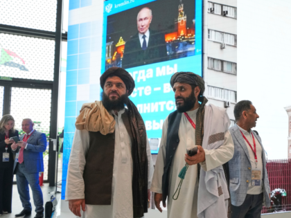 Members of the Taliban stand in front of TV screens as they attend the St. Petersburg Inte