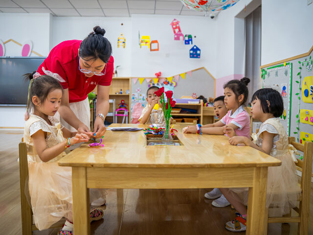 Chinese kindergarten Children make handicrafts under a teacher's guidance ahead of the International Child