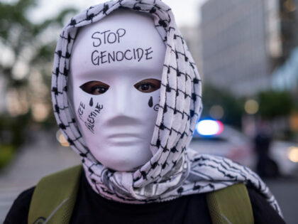 A demonstrator wearing traditional Palestinian Keffiyeh and a mask with Stop Genocide, Fre