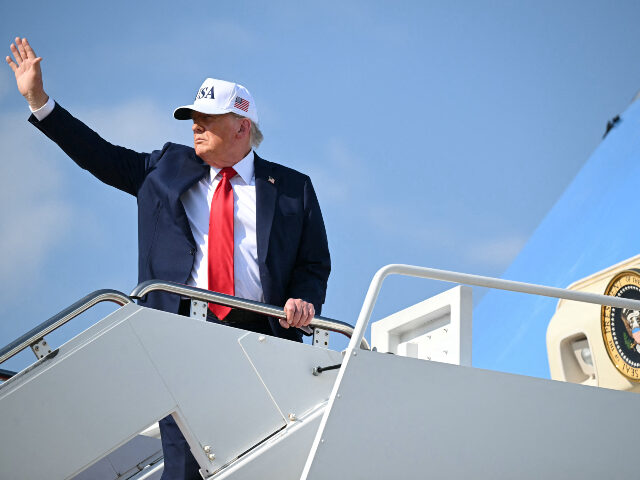US President Donald Trump waves while boarding Air Force One at Joint Base Andrews in Mary