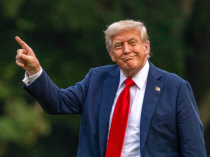 U.S. President Donald Trump walks on the south lawn of the White House and points up at th