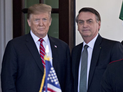 President Donald Trump, left, stands with Jair Bolsonaro, Brazil's president, while a