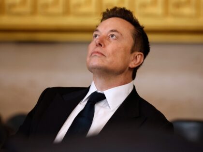 Elon Musk looks up with a grim face