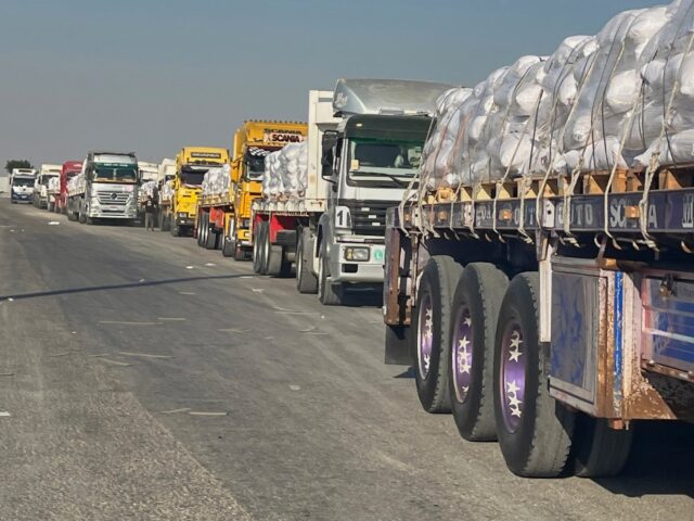 Trucks carrying humanitarian aids line up to enter the Rafah crossing between Egypt and th