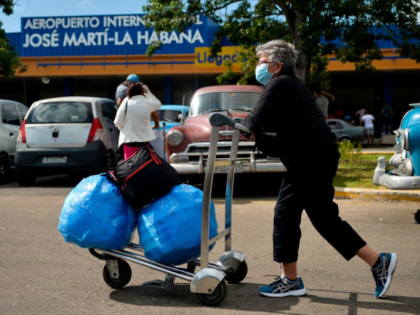 A Cuban-American carries luggage as she leaves Havana's Jose Marti International Airport o