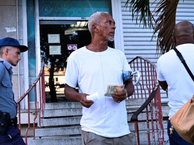 GettyImages-1242669792 A man leaves a bureau de exchange with euros bank notes in Havana, on August 23, 2022. - T