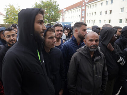 EISENHUETTENSTADT, GERMANY - OCTOBER 05: Men, most of them from Syria, queue for lunch at
