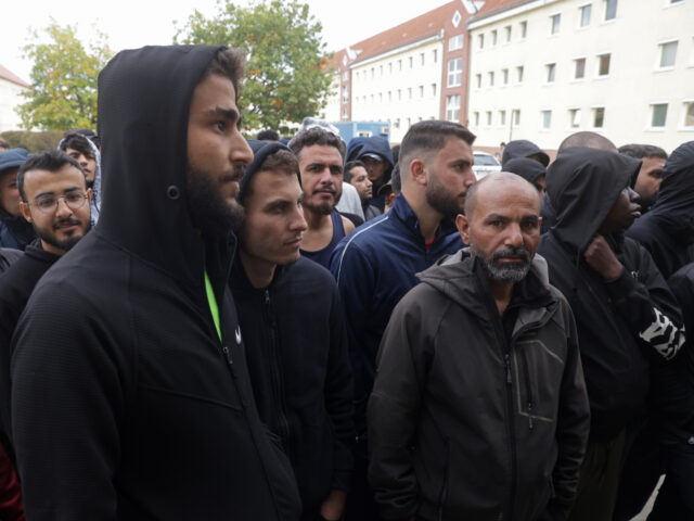 EISENHUETTENSTADT, GERMANY - OCTOBER 05: Men, most of them from Syria, queue for lunch at