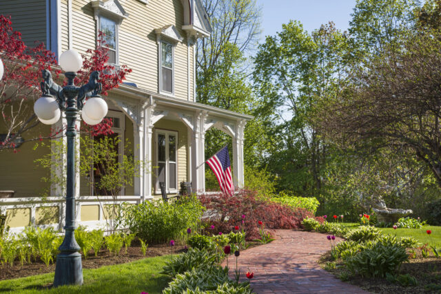 Home facade with front porch and flower-lined brick entrance path, Belfast, Maine, USA