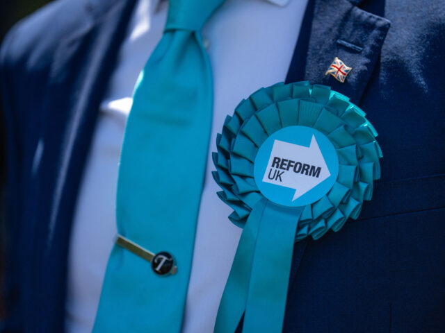 MAIDSTONE, ENGLAND - JUNE 24: A supporter wears a Reform UK rosette before a campaign spee