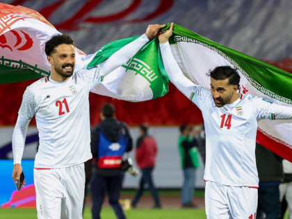 TOPSHOT - Iran's players #21 Omid Norafkan and #14 Saman Ghoddos celebrate after the FIFA