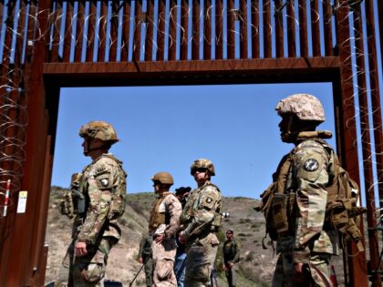 SAN YSIDRO, CA - MARCH 21, 2025 - - Members of the U.S. military are framed by an open ga