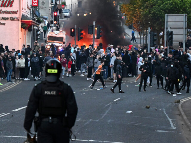 BALLYMENA, NORTHERN IRELAND - JUNE 10: A PSNI Dog Section handler looks on as protesters t