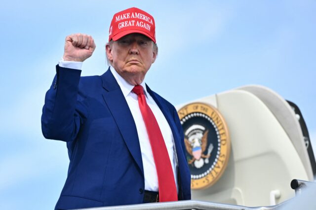 TOPSHOT-US-POLITICS-TRUMP TOPSHOT - US President Donald Trump pumps his fist as he boards Air Force One at Morristow